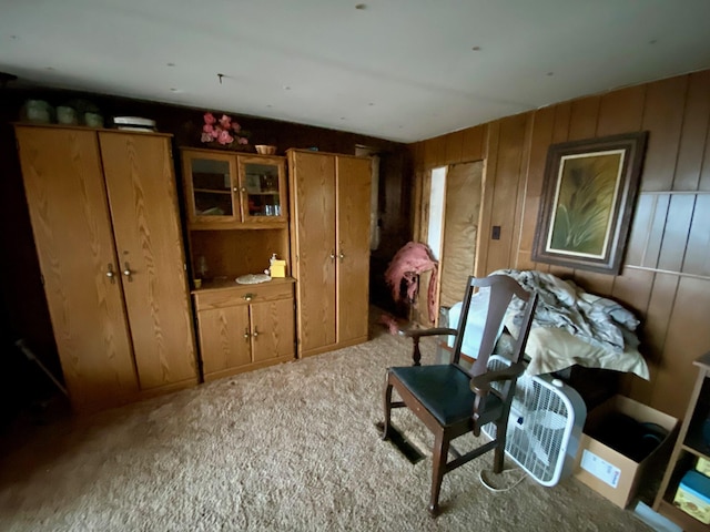 living area featuring carpet flooring and wood walls