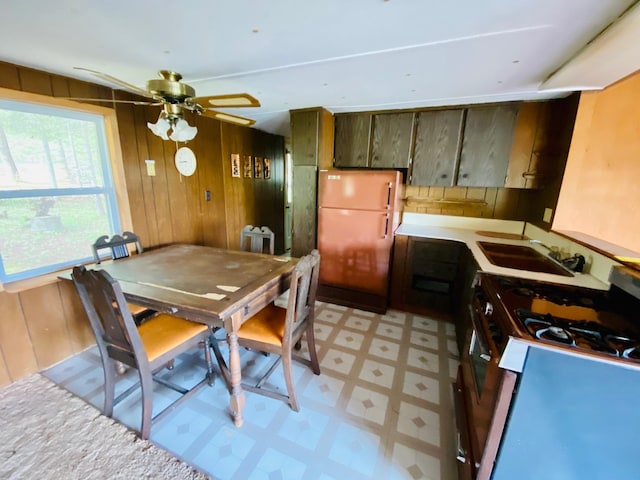 9199 County Road Y, Wascott, WI 54838 - kitchen featuring freestanding refrigerator, gas range, light floors, a sink, and wooden walls