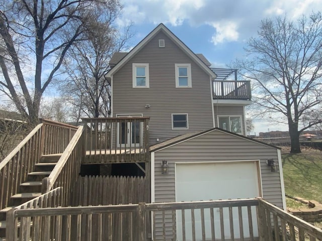 back of house with fence, stairs, a garage, a wooden deck, and a balcony