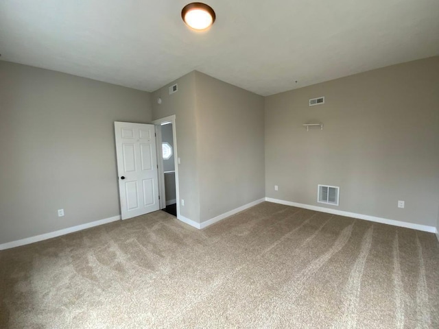 empty room featuring baseboards, carpet flooring, and visible vents