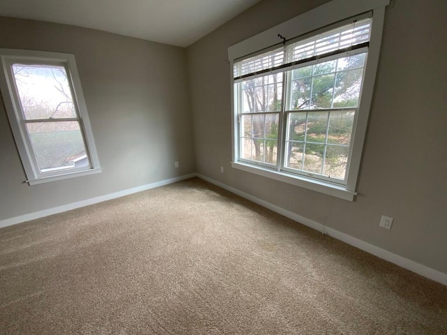 carpeted spare room featuring baseboards
