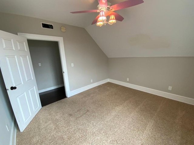 bonus room with ceiling fan, visible vents, dark colored carpet, baseboards, and vaulted ceiling