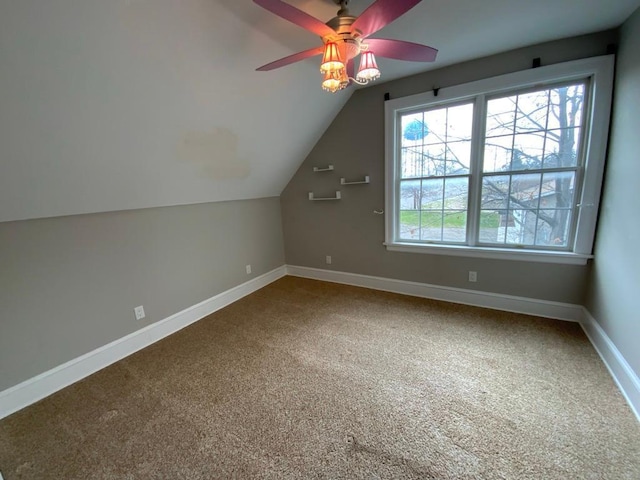 additional living space featuring carpet floors, baseboards, a ceiling fan, and lofted ceiling