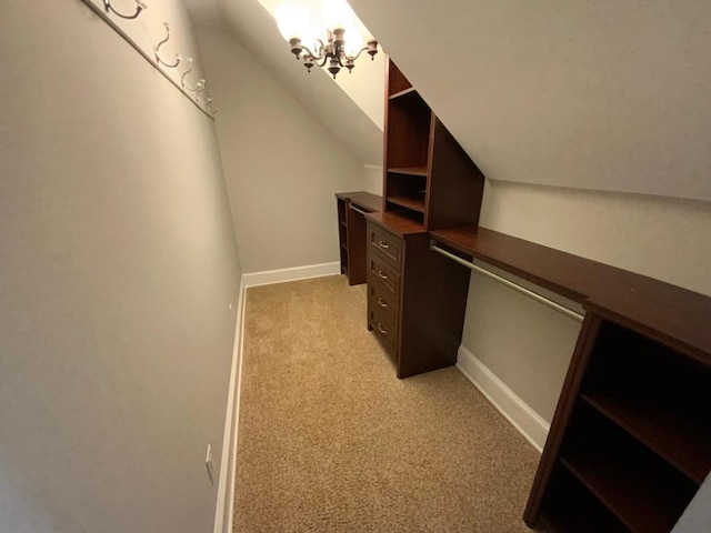 spacious closet featuring vaulted ceiling and light colored carpet