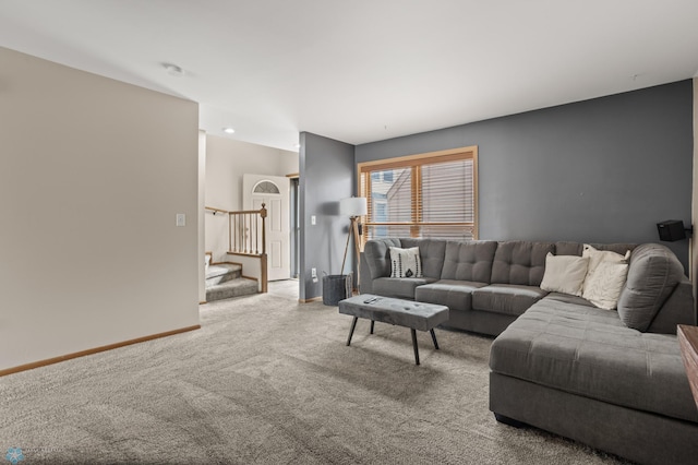 carpeted living room featuring stairway and baseboards