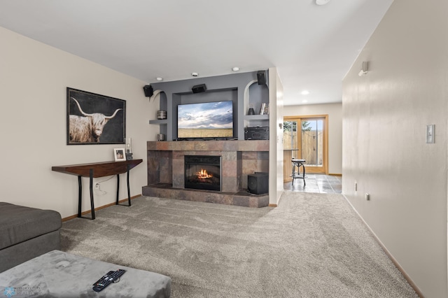 carpeted living area featuring a tiled fireplace and baseboards