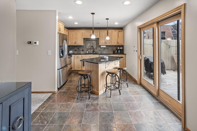 kitchen featuring baseboards, a sink, stainless steel refrigerator with ice dispenser, dark countertops, and backsplash