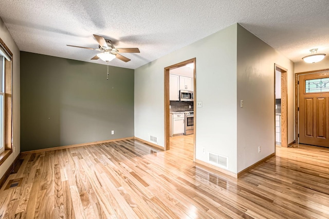 1877 Quasar Ave S, Lake Saint Croix Beach, MN 55043 - empty room featuring a textured ceiling, light wood-style floors, and ceiling fan