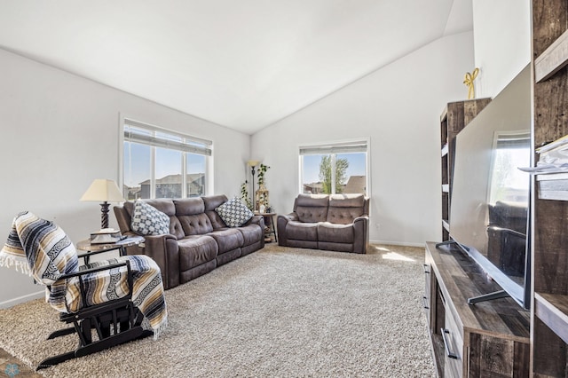 living area with lofted ceiling, plenty of natural light, carpet floors, and baseboards