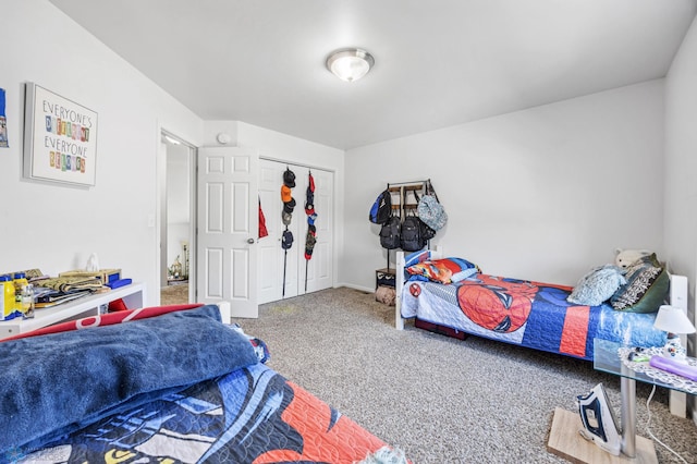 carpeted bedroom with a closet and baseboards