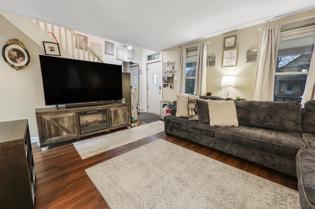 living area with stairs and dark wood-type flooring