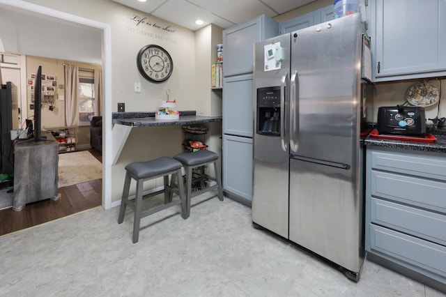 kitchen with stainless steel fridge, dark countertops, baseboards, and recessed lighting