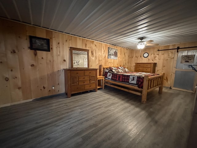 N8690 Island Lake Rd, Casey, WI 54801 - bedroom featuring wooden walls, a barn door, and wood finished floors