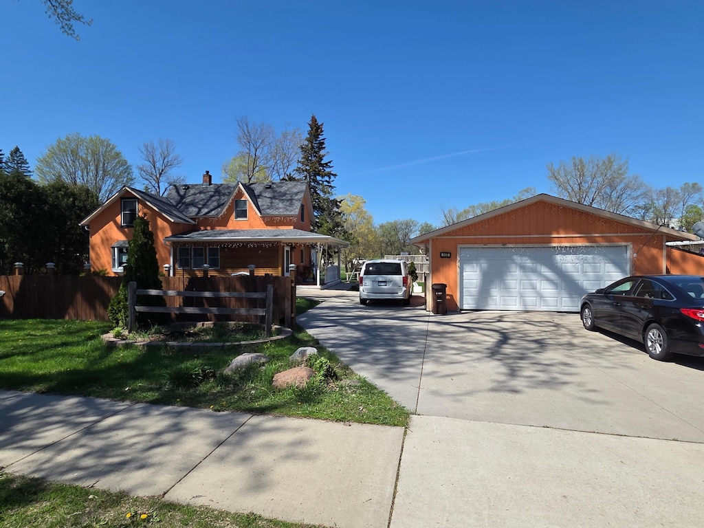 view of side of property featuring a garage and fence