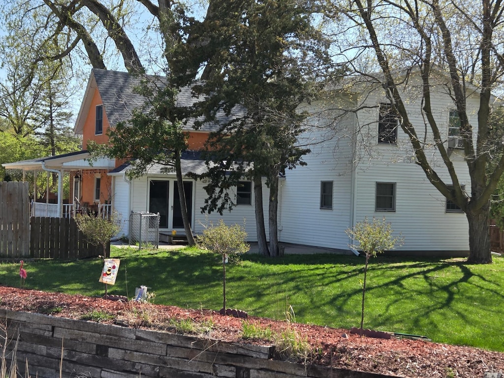 view of front of property with fence, roof with shingles, and a front lawn
