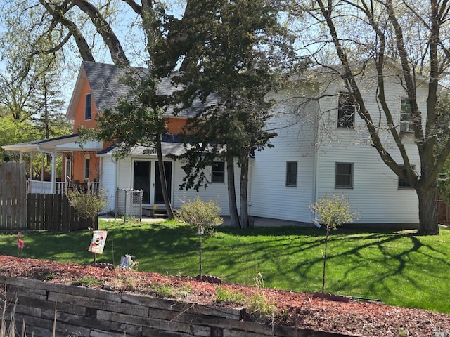 view of front of property with fence, roof with shingles, and a front lawn
