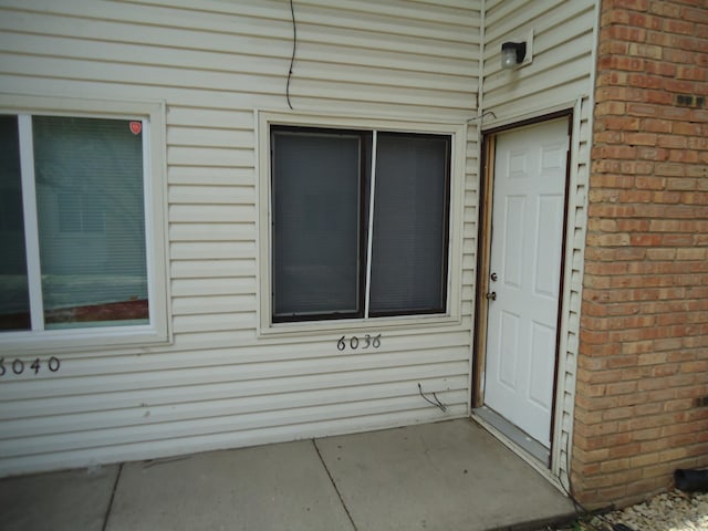 view of exterior entry featuring brick siding