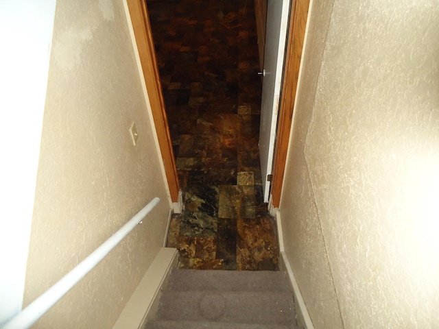 stairway with baseboards and stone finish flooring