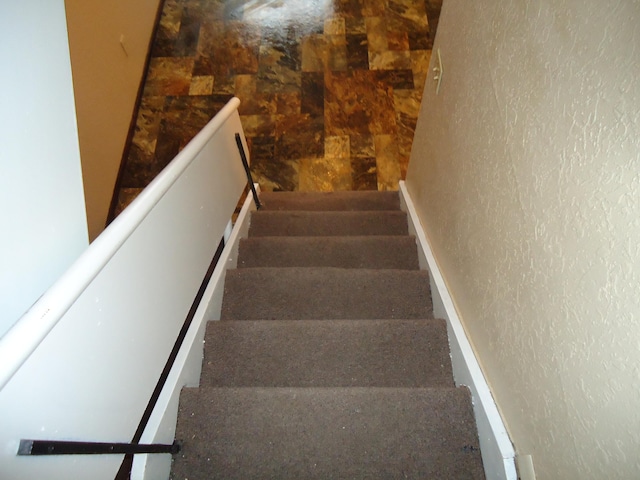stairs featuring a textured wall
