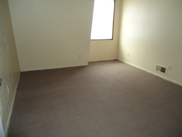 carpeted spare room with baseboards and visible vents