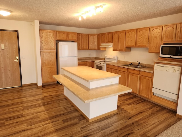 2155 6th Ln SE Unit 212, Cambridge, MN 55008 - kitchen featuring white appliances, under cabinet range hood, a textured ceiling, wood finished floors, and light countertops