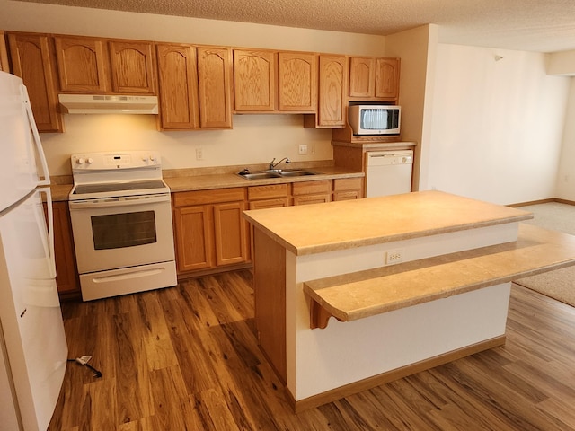 2155 6th Ln SE Unit 212, Cambridge, MN 55008 - kitchen with white appliances, under cabinet range hood, dark wood-type flooring, light countertops, and a textured ceiling