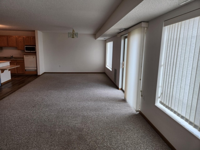 2155 6th Ln SE Unit 212, Cambridge, MN 55008 - unfurnished living room featuring a textured ceiling and dark colored carpet