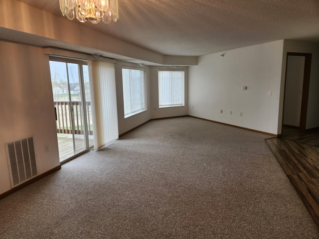 2155 6th Ln SE Unit 212, Cambridge, MN 55008 - empty room with a chandelier, a textured ceiling, and carpet