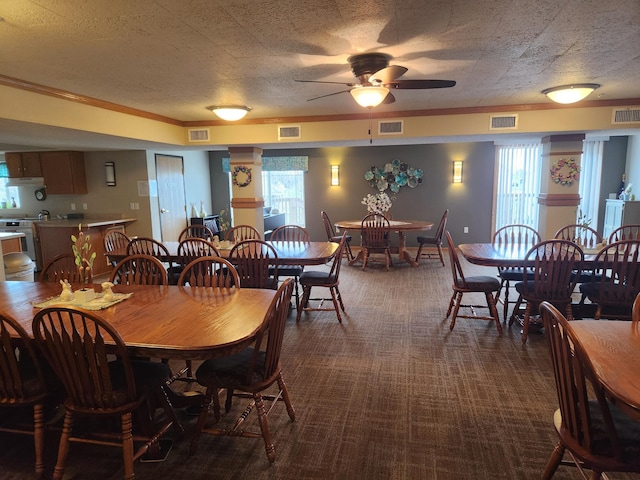 2155 6th Ln SE Unit 212, Cambridge, MN 55008 - dining room featuring ceiling fan, dark colored carpet, and crown molding