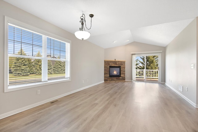 1501 Praha St SE, New Prague, MN 56071 - unfurnished living room featuring lofted ceiling, baseboards, light wood finished floors, visible vents, and a fireplace