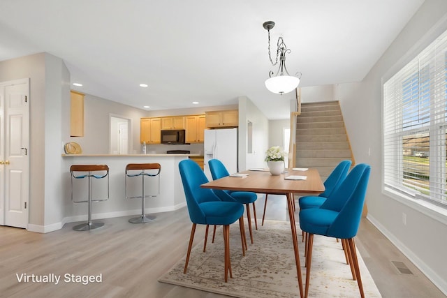 1501 Praha St SE, New Prague, MN 56071 - dining area featuring light wood-type flooring, visible vents, recessed lighting, stairway, and baseboards