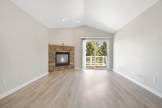 1501 Praha St SE, New Prague, MN 56071 - unfurnished living room featuring visible vents, vaulted ceiling, a fireplace, light wood-style flooring, and baseboards