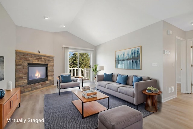 1501 Praha St SE, New Prague, MN 56071 - living room with light wood finished floors, visible vents, lofted ceiling, and a stone fireplace