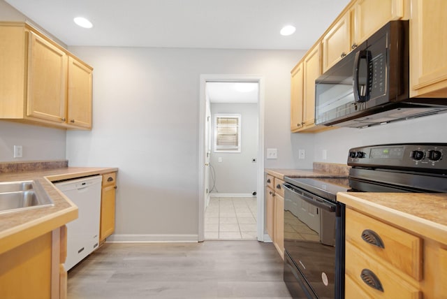 1501 Praha St SE, New Prague, MN 56071 - kitchen with light countertops, baseboards, black appliances, and light brown cabinetry