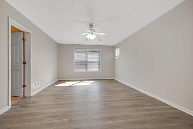 1501 Praha St SE, New Prague, MN 56071 - unfurnished room featuring baseboards, visible vents, light wood-type flooring, and ceiling fan