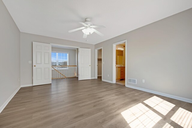 1501 Praha St SE, New Prague, MN 56071 - unfurnished bedroom featuring ensuite bathroom, wood finished floors, visible vents, a spacious closet, and baseboards