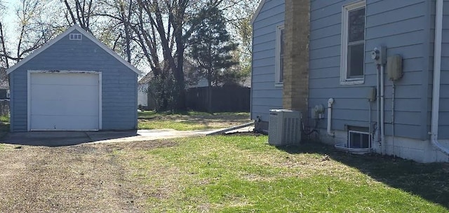 view of yard with central air condition unit, an outdoor structure, and a garage