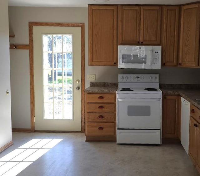 kitchen featuring white appliances and brown cabinetry