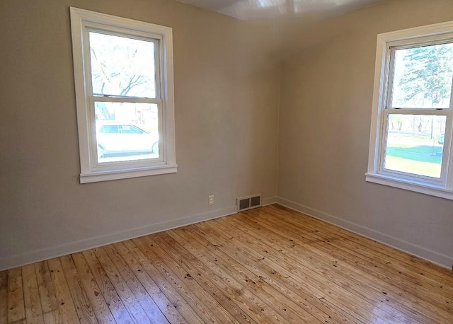 spare room with visible vents, baseboards, and light wood finished floors