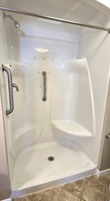 full bath with baseboards and a shower stall