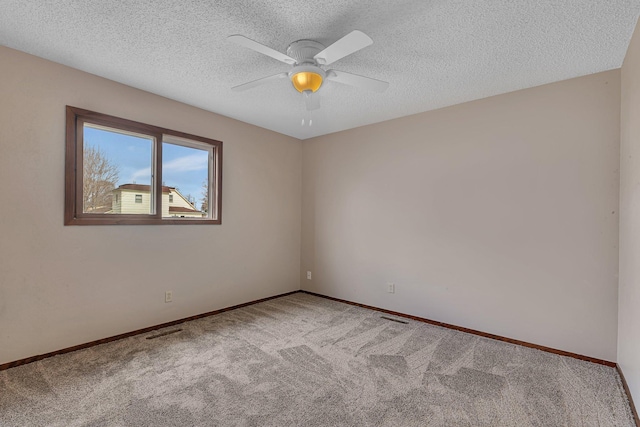 empty room featuring visible vents, a ceiling fan, carpet, and baseboards