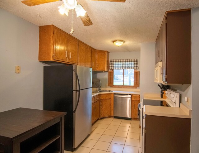 11342 Ibis St NW, Coon Rapids, MN 55433 - kitchen featuring appliances with stainless steel finishes, ceiling fan, a sink, a textured ceiling, and brown cabinetry