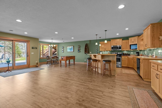 25124 Firefly Ave, Wyoming, MN 55092 - kitchen featuring appliances with stainless steel finishes, a kitchen breakfast bar, a chandelier, recessed lighting, and light wood-style floors