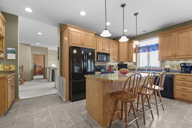 25124 Firefly Ave, Wyoming, MN 55092 - kitchen with black appliances, a center island, dark countertops, hanging light fixtures, and a breakfast bar area