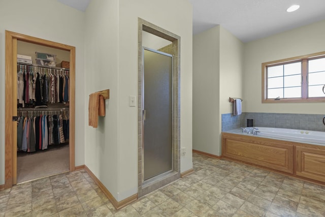25124 Firefly Ave, Wyoming, MN 55092 - bathroom with a stall shower, a bath, a walk in closet, baseboards, and stone finish flooring