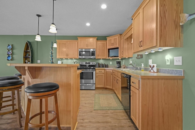 25124 Firefly Ave, Wyoming, MN 55092 - kitchen with stainless steel appliances, a sink, light brown cabinetry, a breakfast bar, and light countertops