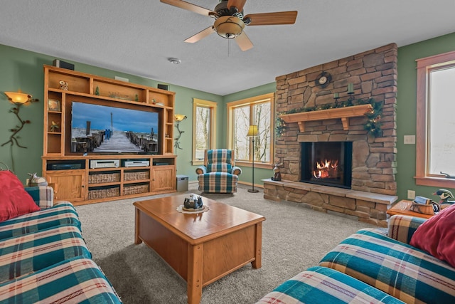 25124 Firefly Ave, Wyoming, MN 55092 - living room with carpet floors, ceiling fan, a stone fireplace, and a textured ceiling