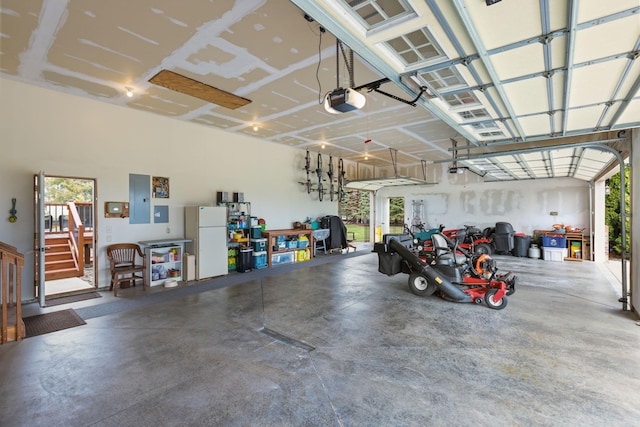 25124 Firefly Ave, Wyoming, MN 55092 - garage featuring freestanding refrigerator, electric panel, and a garage door opener