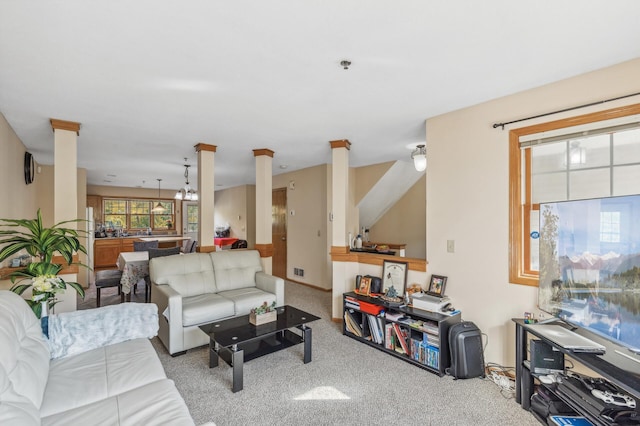 living area with visible vents, carpet, and decorative columns