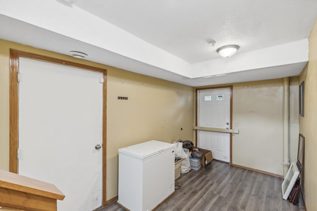laundry room featuring baseboards and wood finished floors